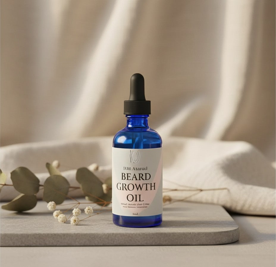 Oh Canada Gifts handcrafted beard oil in a blue glass dropper bottle on a stone surface with dried eucalyptus.