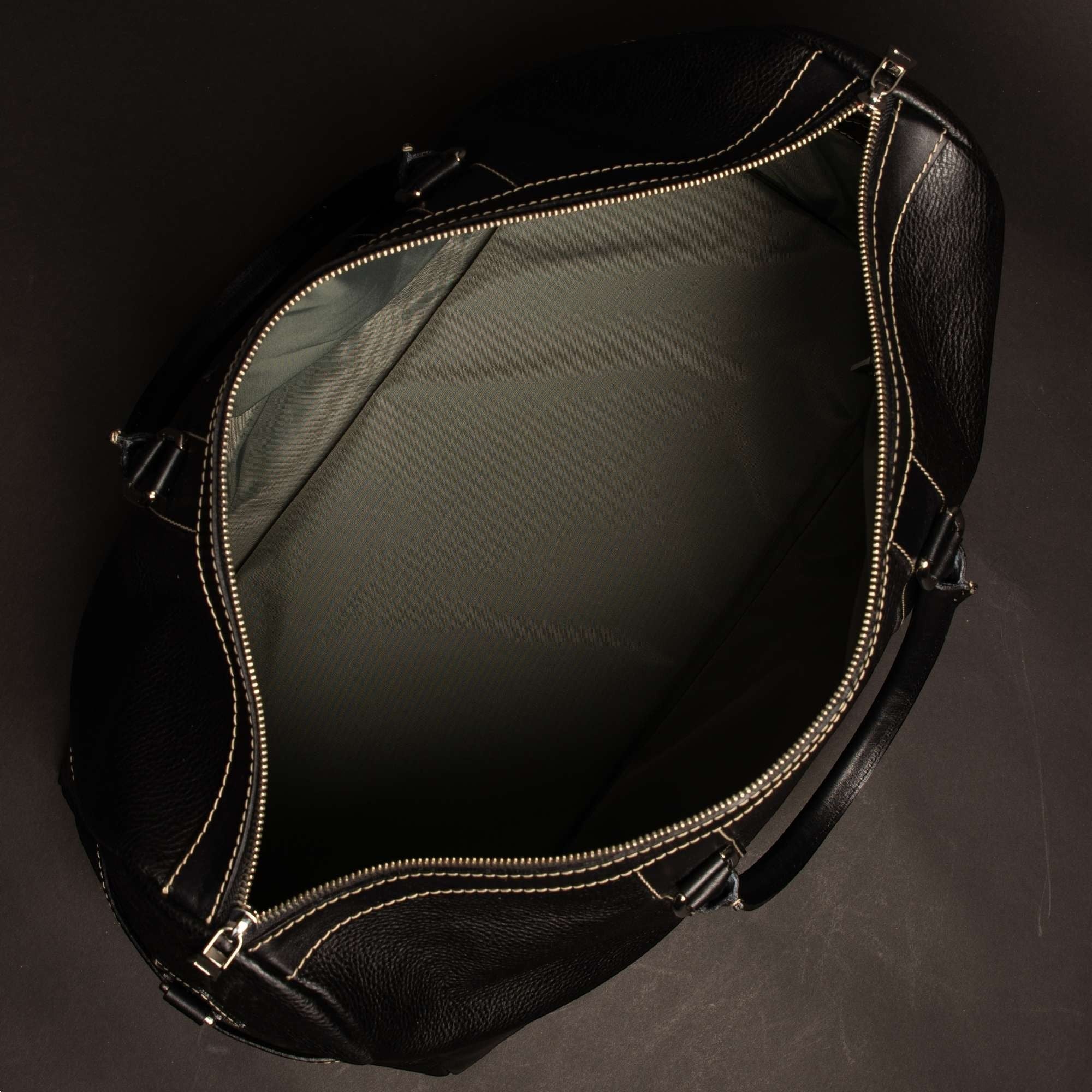 Oh Canada Gifts Shield duffle bag in black full-grain leather, shown from an open top-down view.