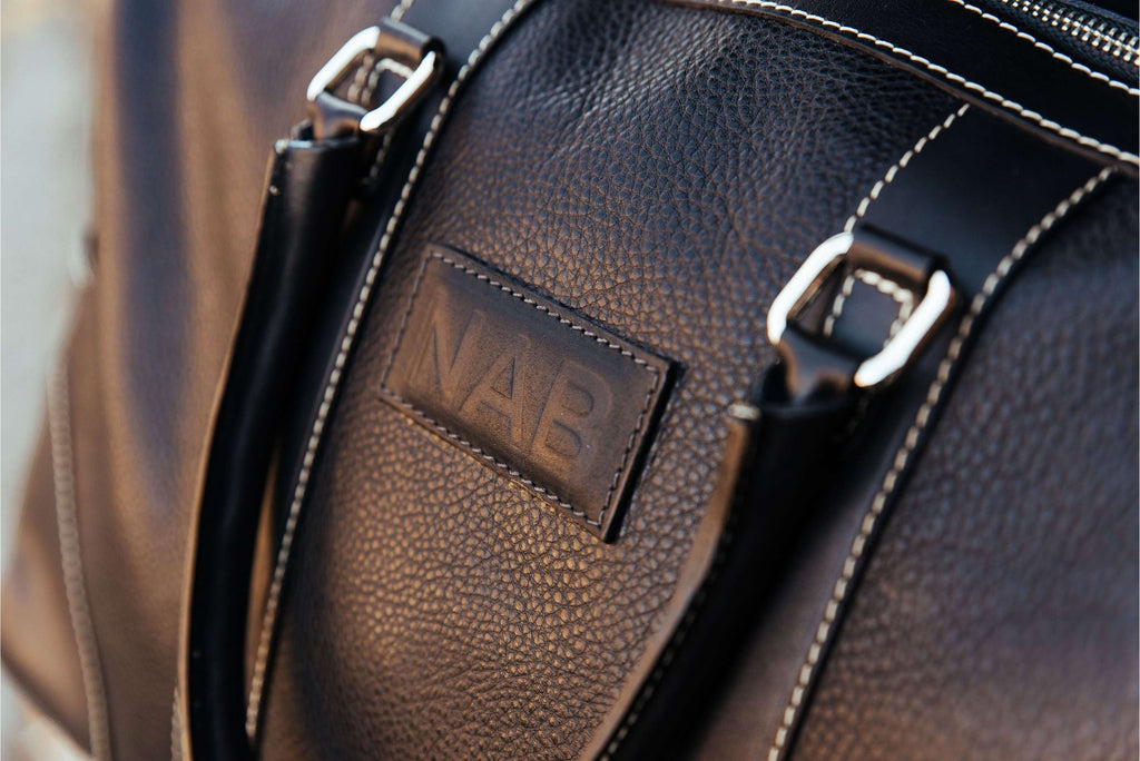 Oh Canada Gifts Shield Duffle bag in black full-grain leather with NAB branding and detailed stitching