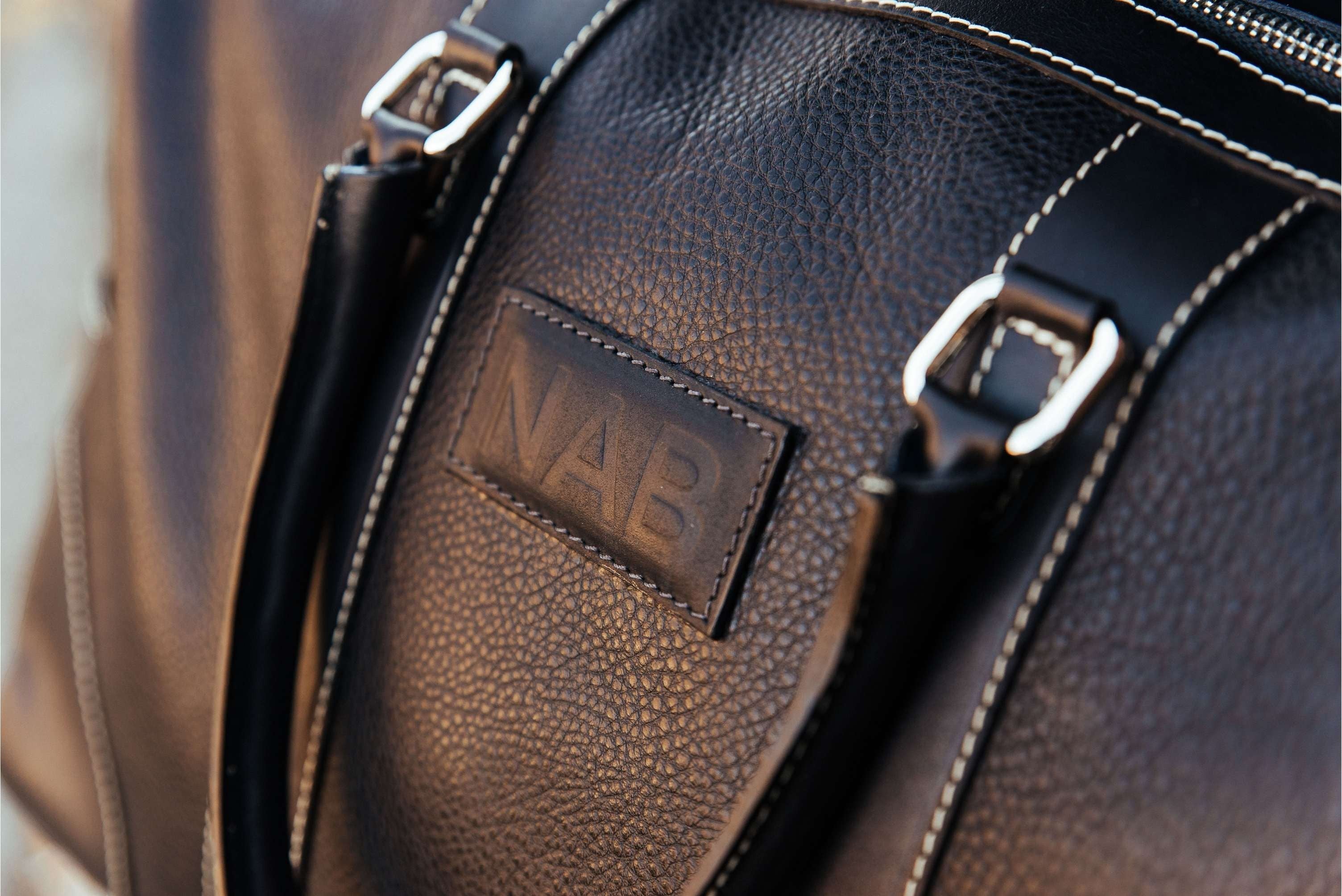 Oh Canada Gifts Shield Duffle bag in black full-grain leather with NAB branding and detailed stitching