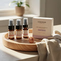 Oh Canada Gifts Cocoon Apothecary travel-size skincare kit with cleanser, toner, and cream on a wooden tray.