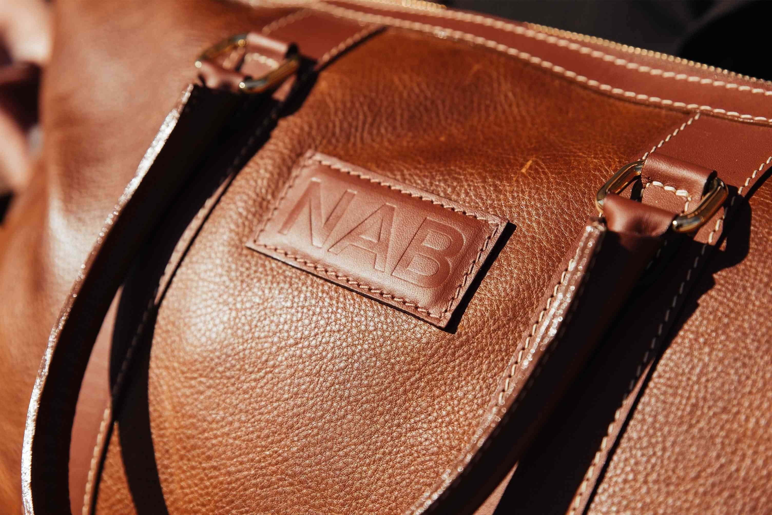 Oh Canada Gifts NAB Leather Shield Duffle bag in cognac full-grain leather with embossed logo detail