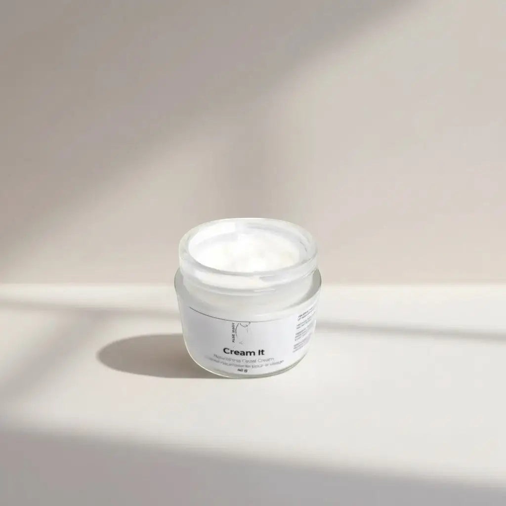 Oh Canada Gifts Cream It nourishing facial moisturizer in an open glass jar with a white whipped cream texture.