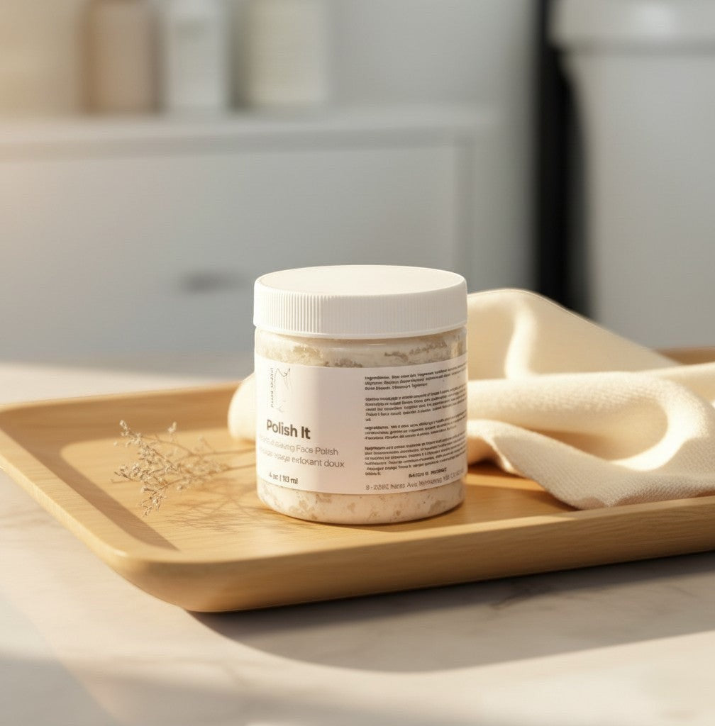 Oh Canada Gifts Polish It creamy exfoliant in a 4 oz jar on a wooden tray with a soft cloth for gentle skincare.