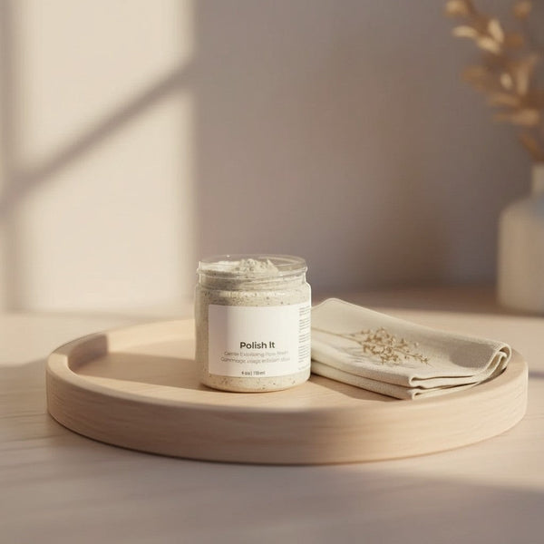 Oh Canada Gifts Polish It creamy exfoliant in a clear jar on a wooden tray with a cloth, featuring botanical texture.
