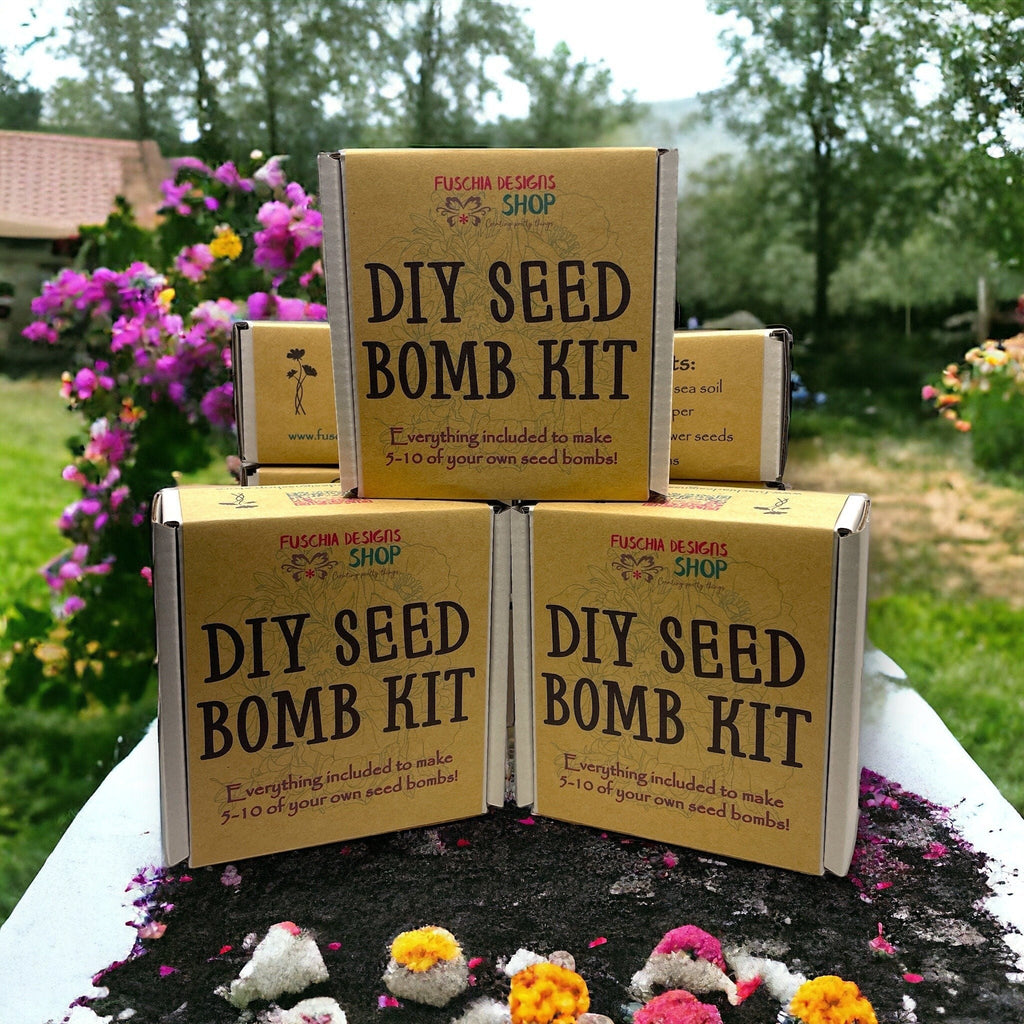 Oh Canada Gifts DIY seed bomb kit boxes stacked outdoors with wildflower garden background