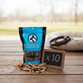Oh Canada Gifts bulk case of 10 bags of natural dried sardine pet treats on a wooden surface with a chalkboard sign.