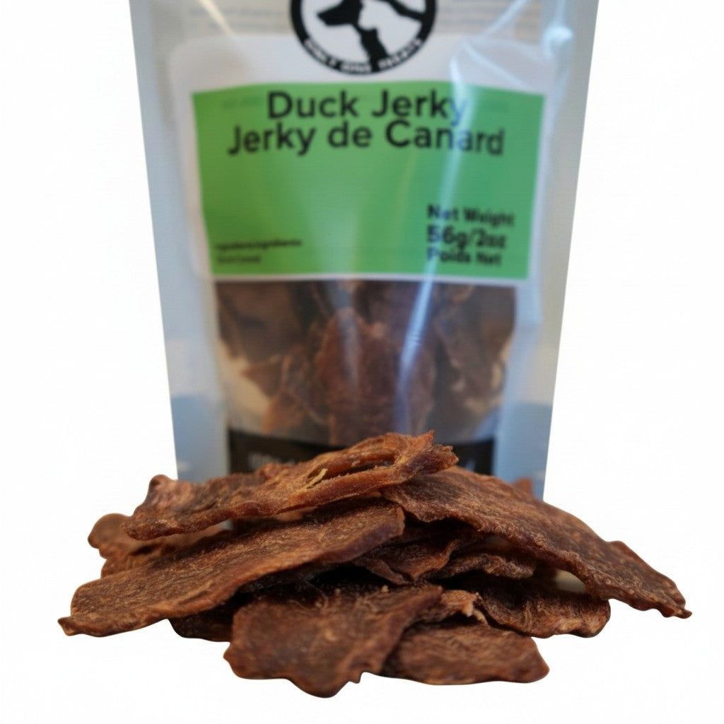 Oh Canada Gifts duck jerky dog treats in a 56g bag with chewy, slow-cooked meat slices in the foreground.