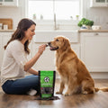Oh Canada Gifts duck liver jerky treat being fed by a woman to her golden retriever in a bright kitchen