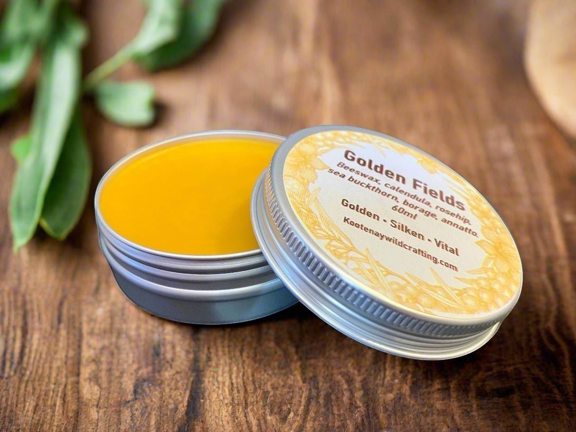 Oh Canada Gifts Golden Fields skin salve in a small metal tin with a golden herbal balm on a rustic wooden surface.