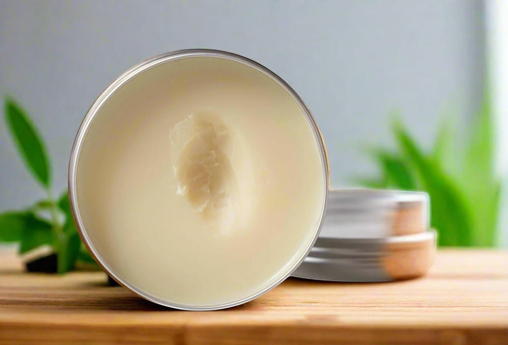 Oh Canada Gifts pure grass-fed Canadian tallow balm in an open metal tin on a wooden surface with green foliage