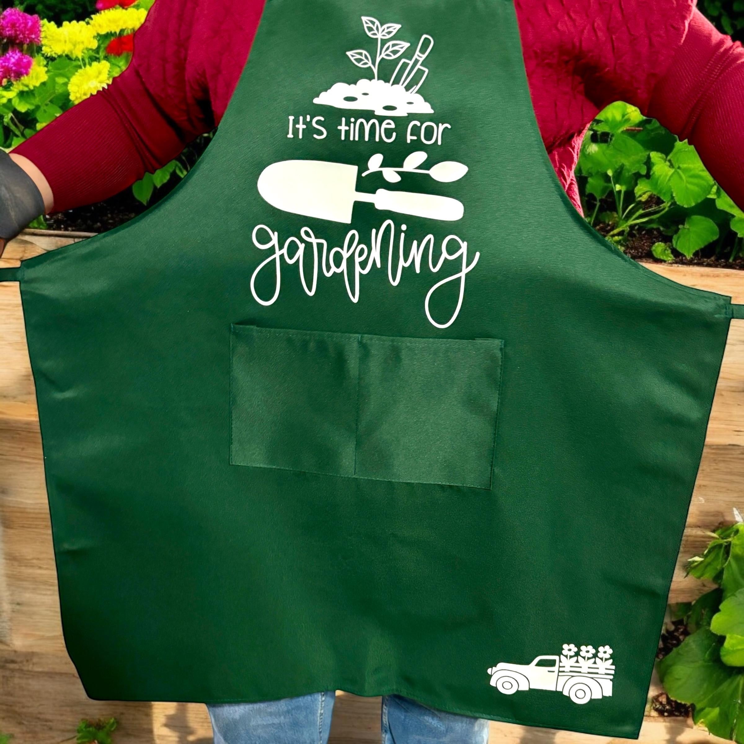 Oh Canada Gifts green gardening apron with pockets, white text, and garden tool graphics worn by a gardener