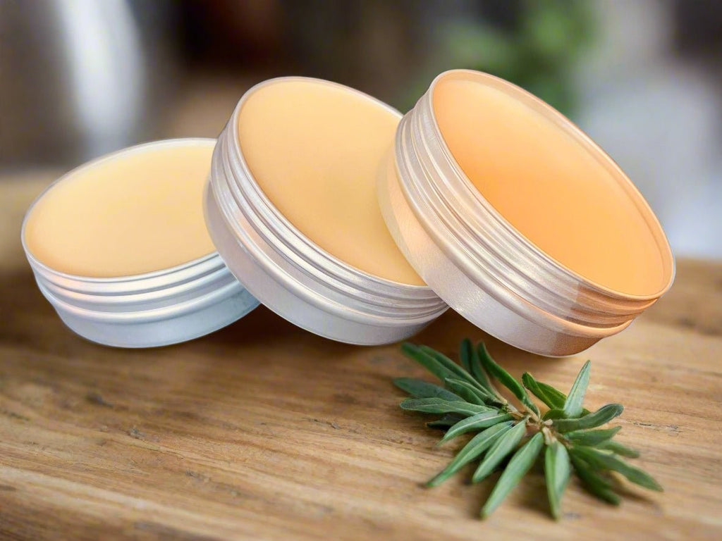 Oh Canada Gifts Heritage Salve Collection featuring three small round tins of natural herbal balms on a wooden surface.