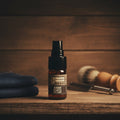 Oh Canada Gifts Humidor beard oil in a glass bottle with a pump, set on a wooden shelf with a shaving brush and razor.