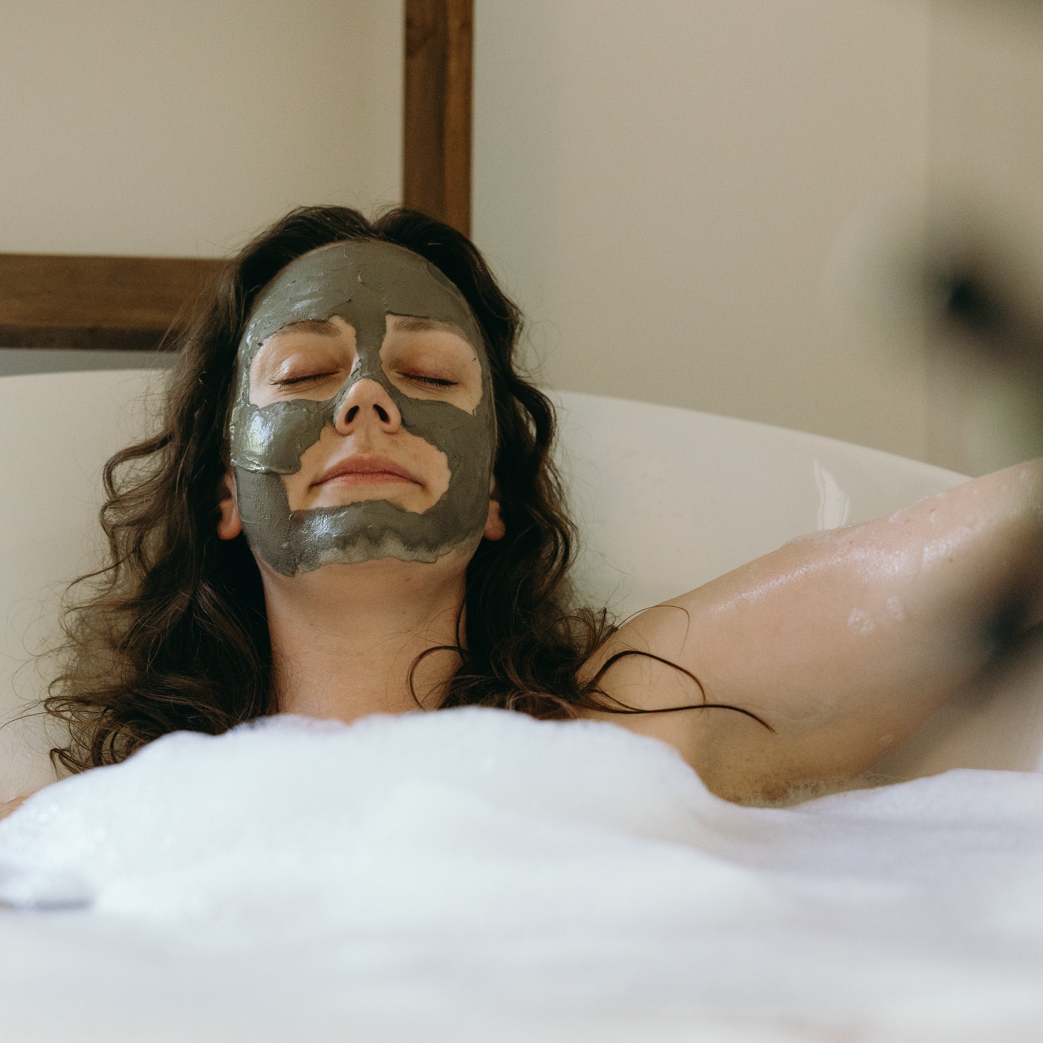Oh Canada Gifts Kahuna bubble bath with a woman relaxing in a tub wearing a grey clay face mask
