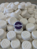 Oh Canada Gifts Zen & Hearth lavender shower steamers, white round effervescent tablets with embossed logo in a pile.