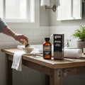 Oh Canada Gifts Malechemy Muskoka aftershave bottle and box on a wooden bathroom vanity with a shaving brush and razor.
