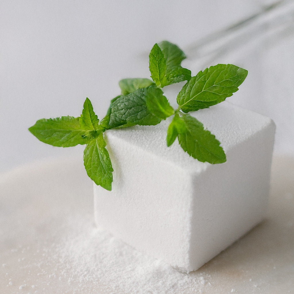 Oh Canada Gifts mint eucalyptus bath cube with fresh green mint leaves on a white surface