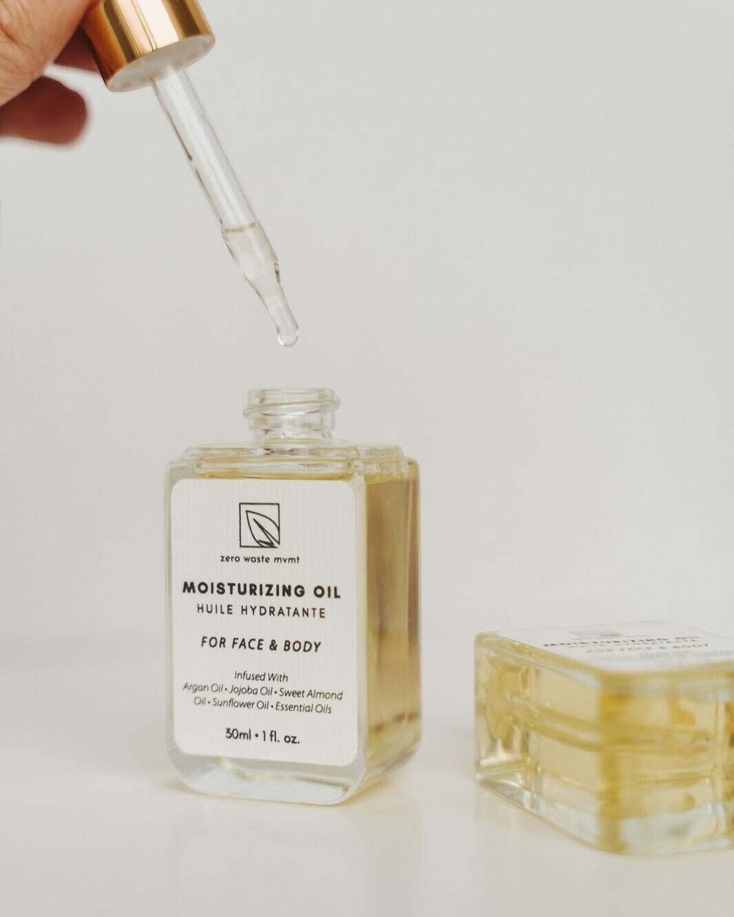 Oh Canada Gifts Zero Waste MVMT moisturizing oil in a glass bottle with a dropper, featuring botanical ingredients.