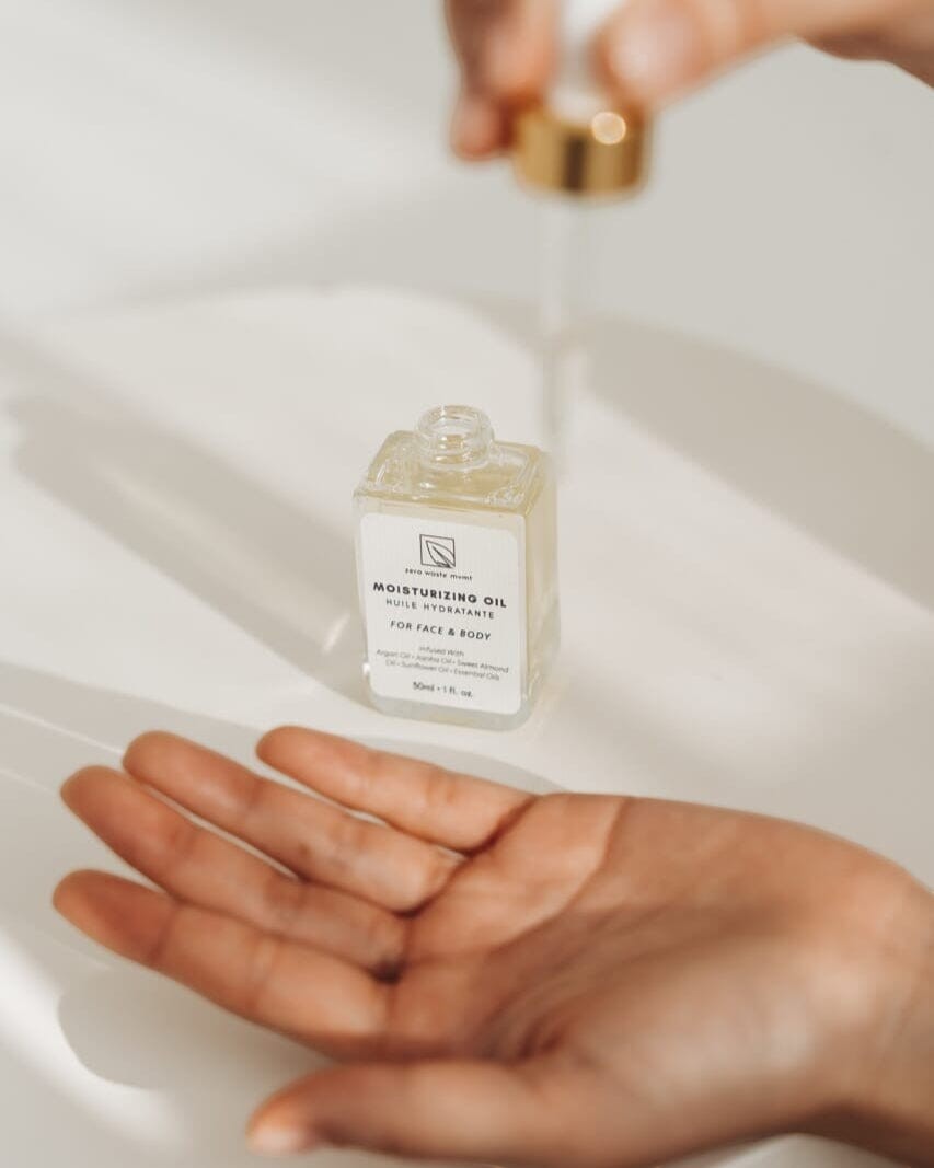 Oh Canada Gifts Zero Waste MVMT moisturizing oil in a glass dropper bottle being applied to hands.