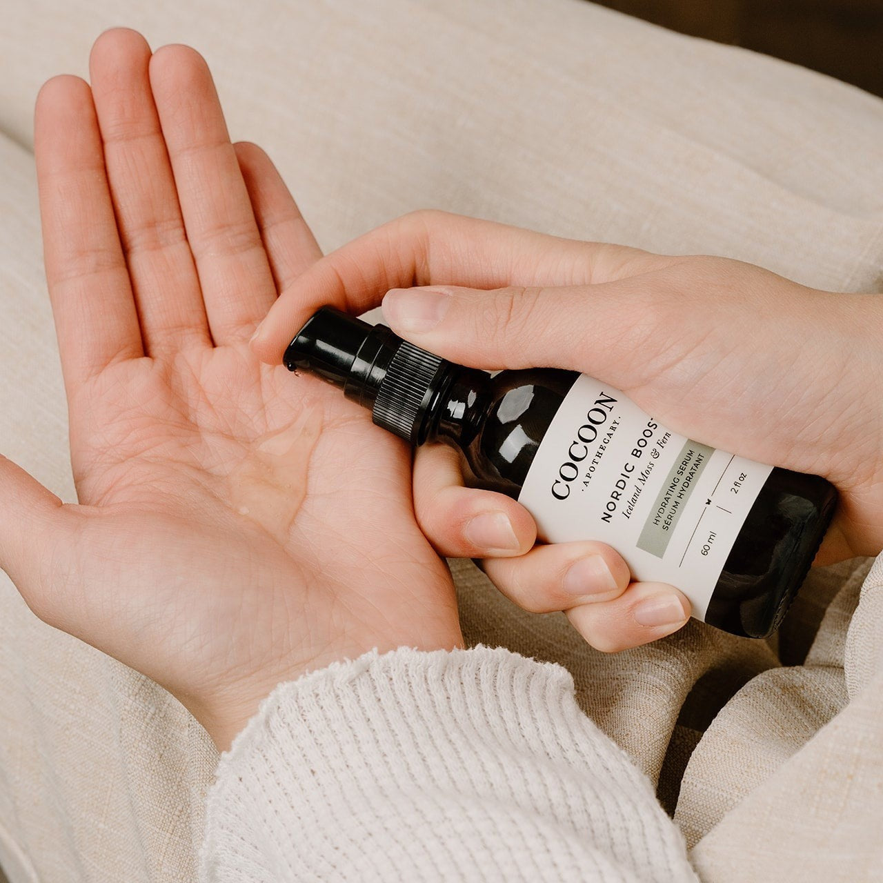 Oh Canada Gifts Nordic Boost hydrating serum being dispensed into a hand for application