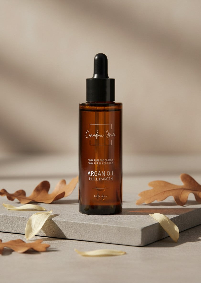 Oh Canada Gifts organic cold-pressed argan oil in an amber glass dropper bottle on a stone base with autumn leaves.