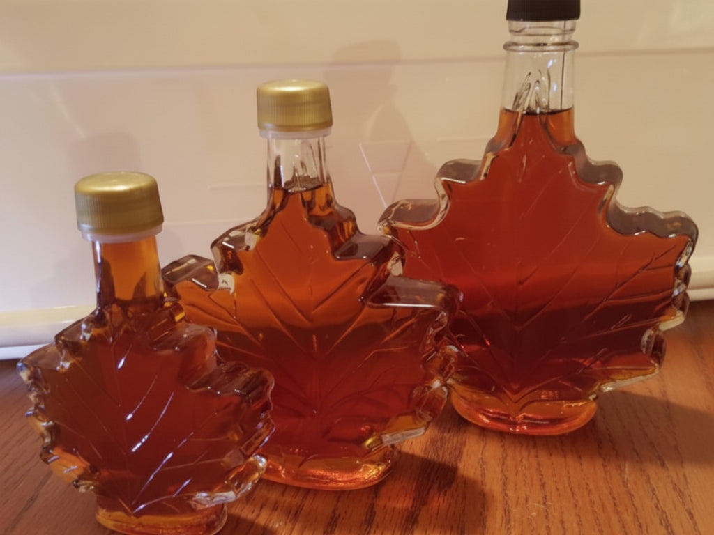 Oh Canada Gifts organic maple syrup in three different sizes of iconic glass maple leaf-shaped bottles.