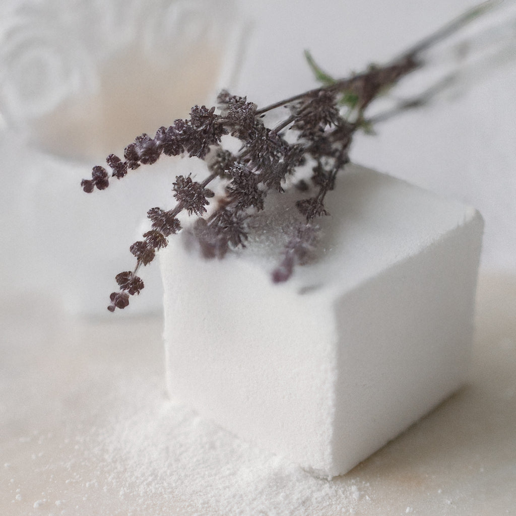 Oh Canada Gifts Patchouli Vibes bath cube with dried botanicals on a white surface for a relaxing mineral soak