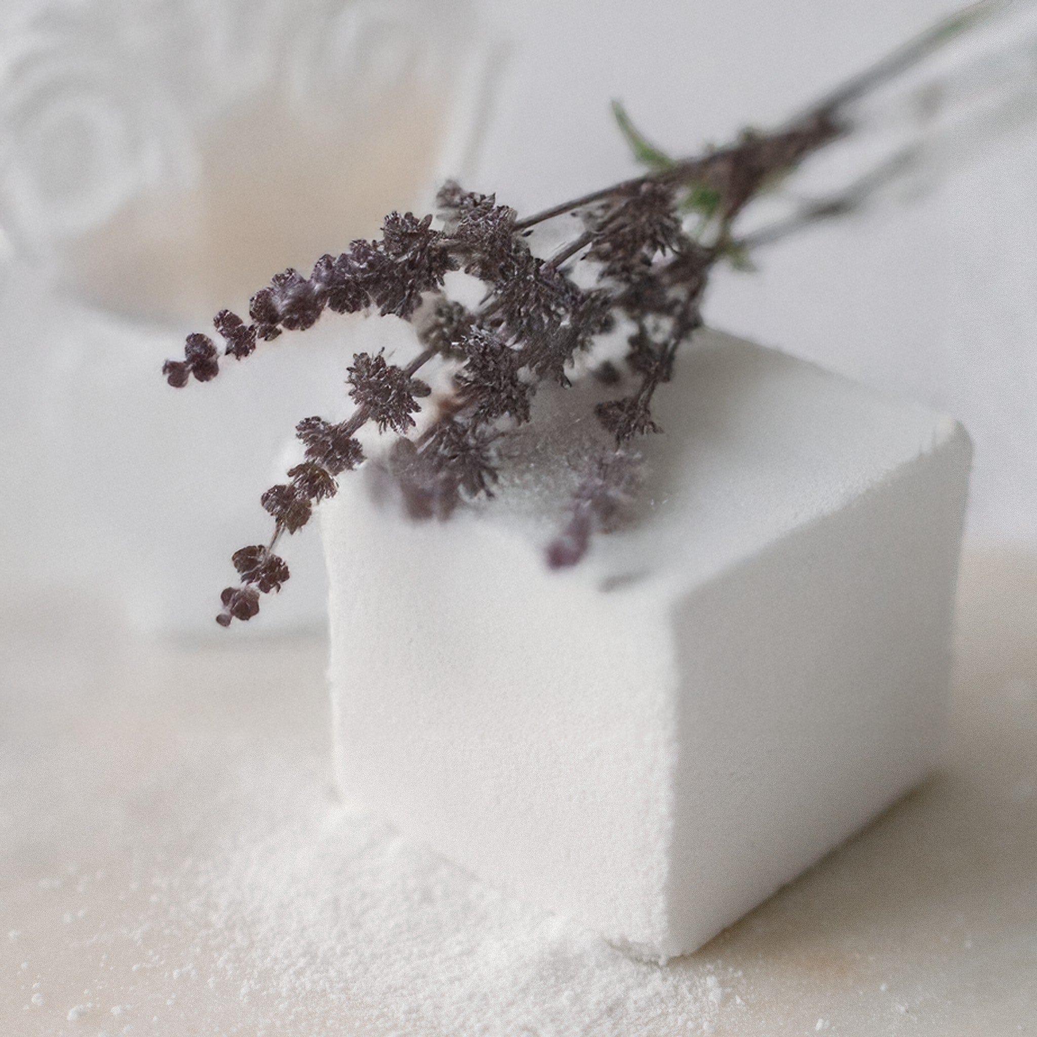 Oh Canada Gifts Patchouli Vibes bath cube with dried botanicals on a white surface for a relaxing mineral soak