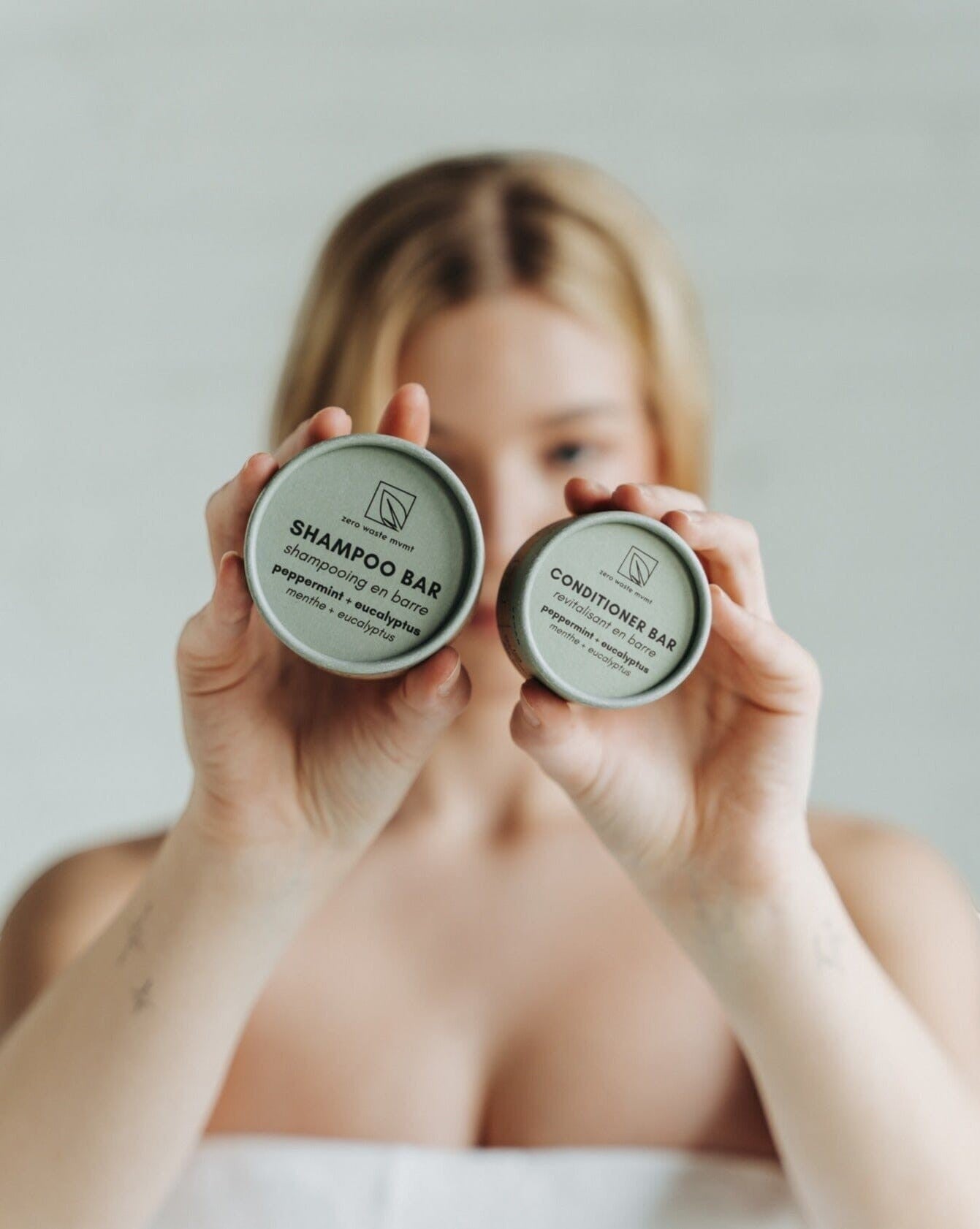 Oh Canada Gifts Zero Waste MVMT peppermint and eucalyptus conditioner and shampoo bars held by a woman