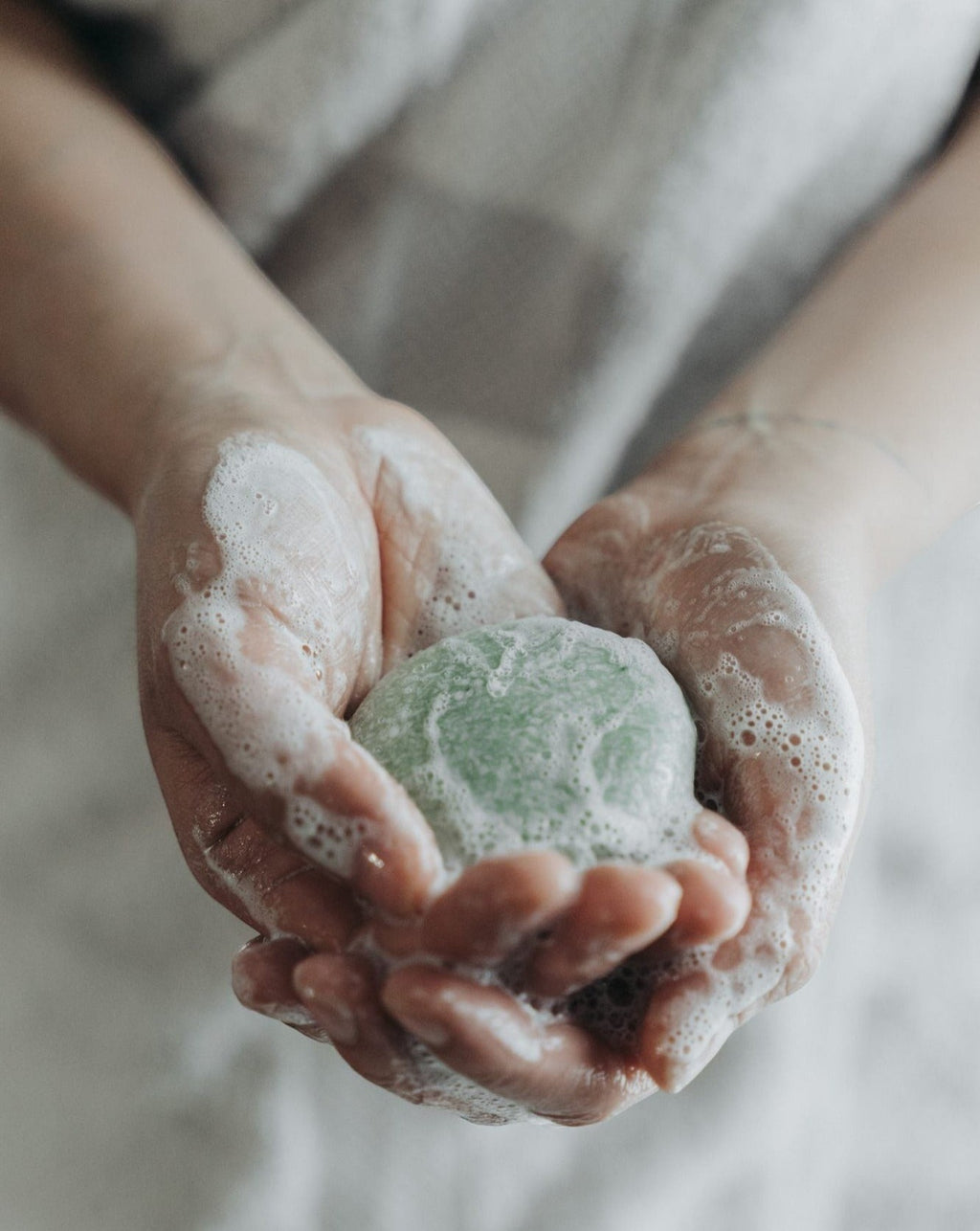 Oh Canada Gifts peppermint and eucalyptus shampoo bar held in hands with rich lather for a zero-waste hair wash