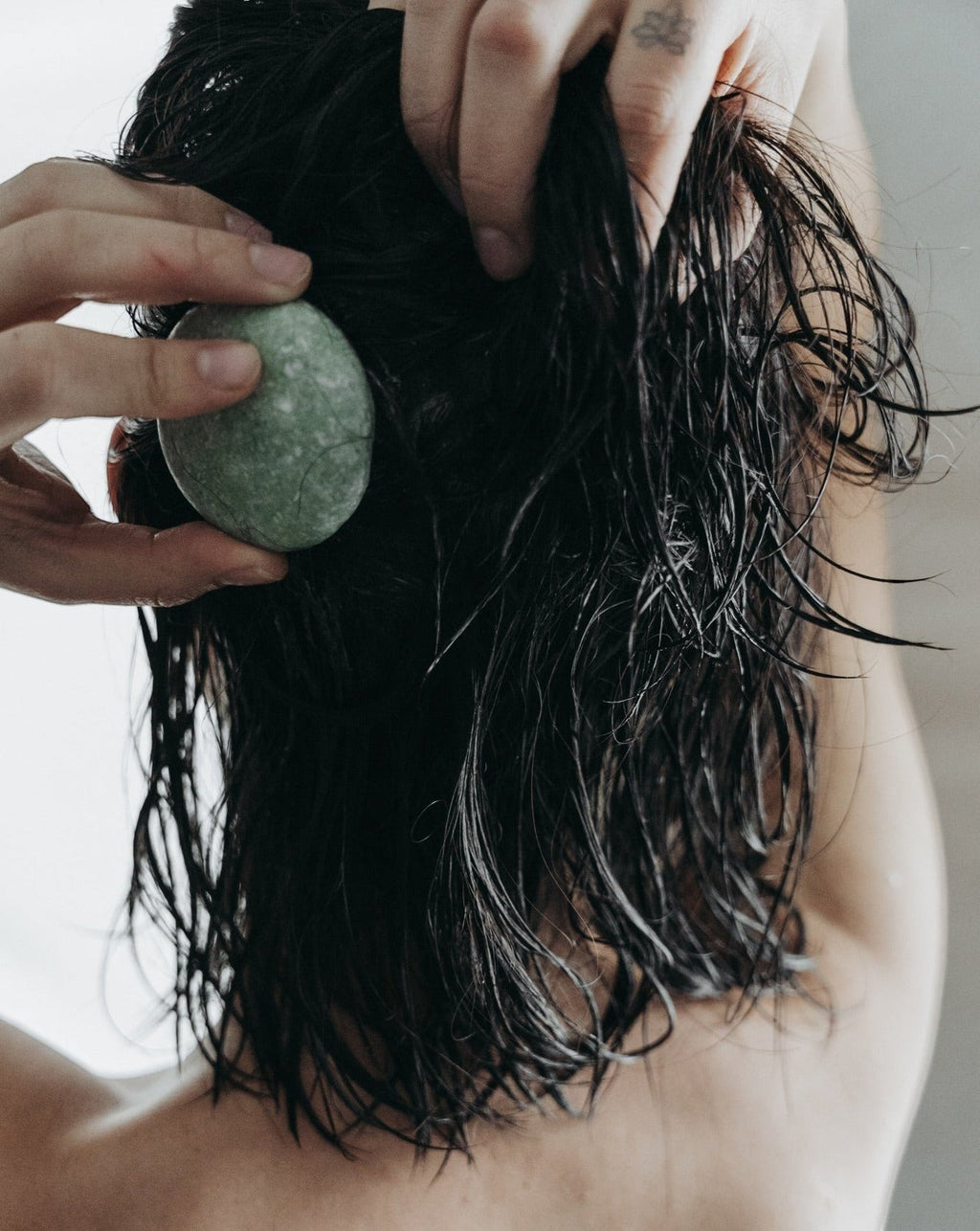 Oh Canada Gifts peppermint and eucalyptus shampoo bar being applied to wet hair for a refreshing scalp cleanse.