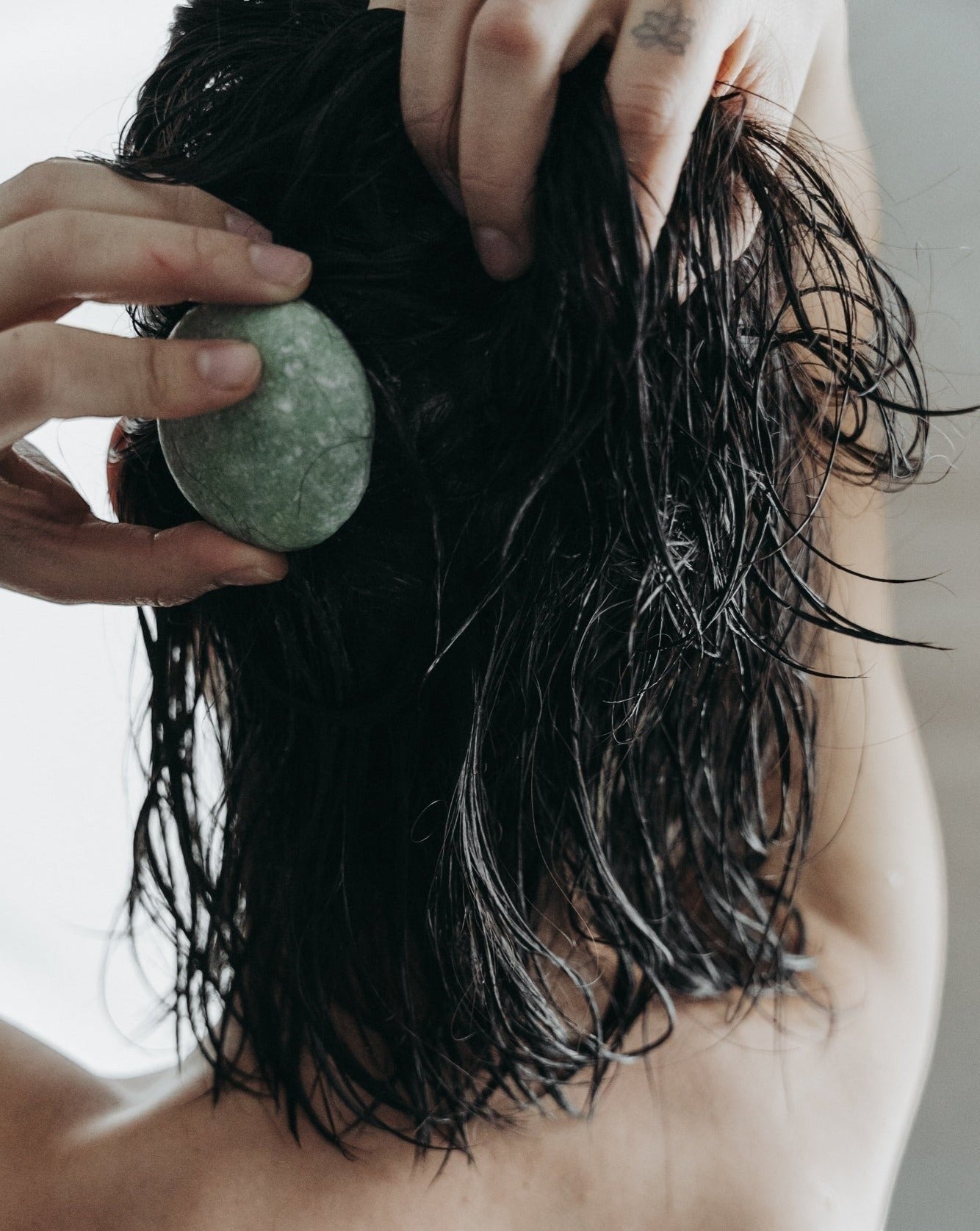 Oh Canada Gifts peppermint and eucalyptus shampoo bar being applied to wet hair for a refreshing scalp cleanse.