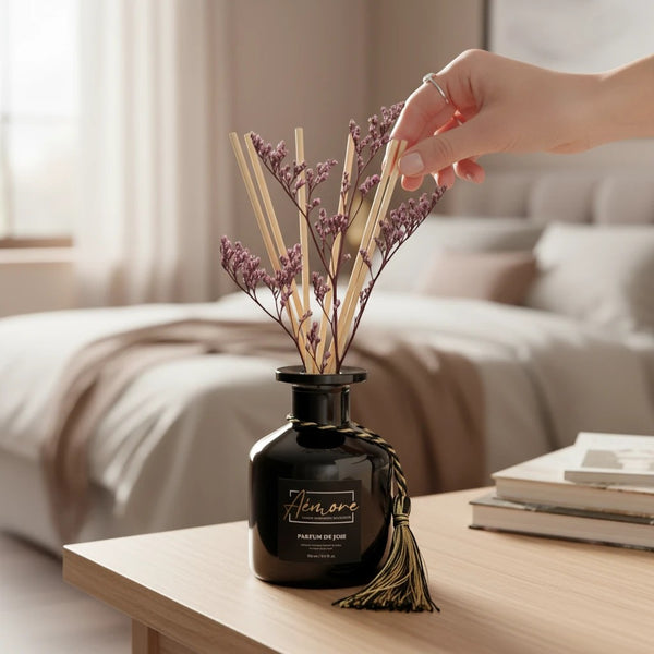 Oh Canada Gifts Parfum de Joie reed diffuser with preserved flowers and decorative tassel in a black glass bottle.
