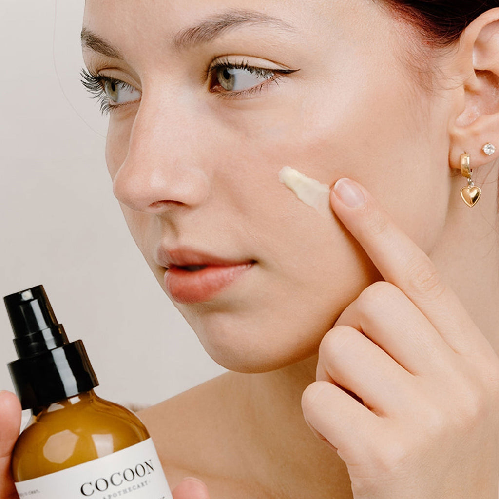 Oh Canada Gifts Rosey Cheeks facial cream being applied to a model's cheek to soothe dry and sensitive skin.