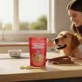Oh Canada Gifts soft wild Pacific salmon training treats in a red bag on a table with a dog and owner in background