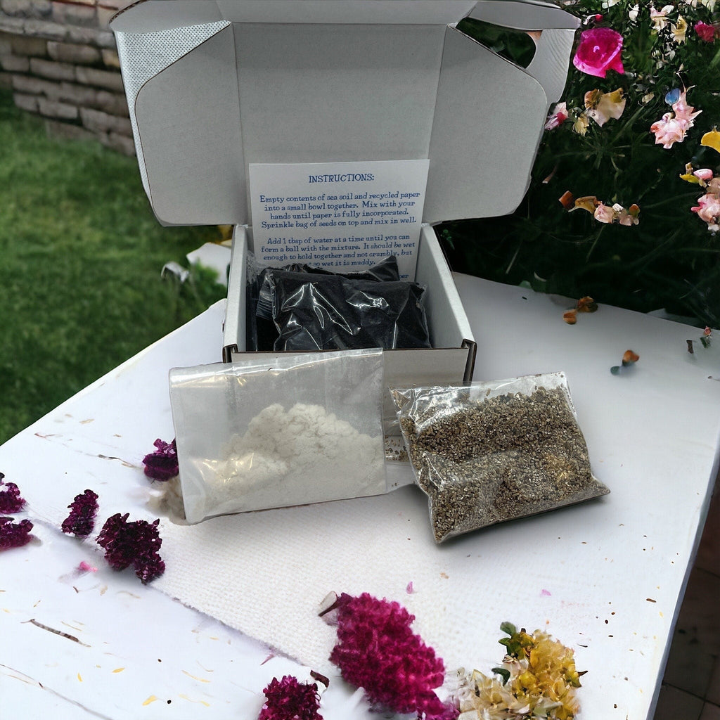 Oh Canada Gifts DIY seed bomb kit with soil, recycled paper, and wildflower seeds in individual packets on a table