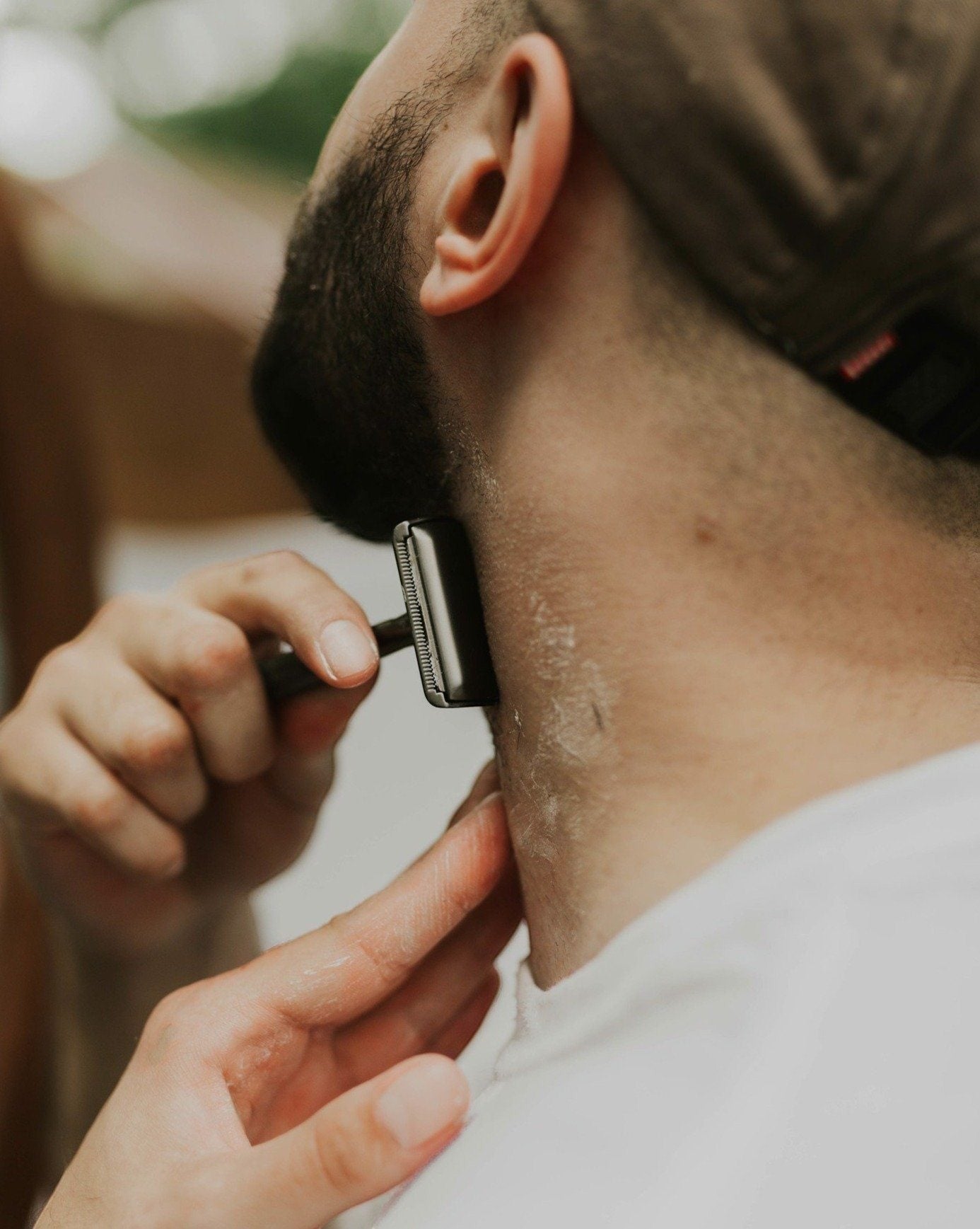 Oh Canada Gifts shave bar lather applied to a man's neck while shaving with a safety razor
