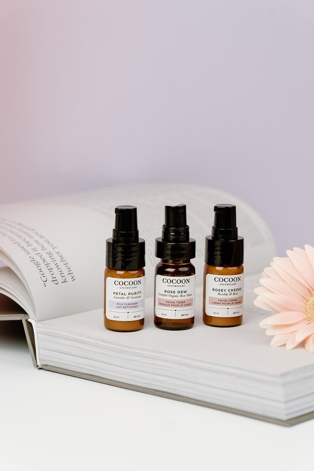 Oh Canada Gifts Cocoon Apothecary travel-size skincare starter kit with cleanser, toner, and cream on an open book.