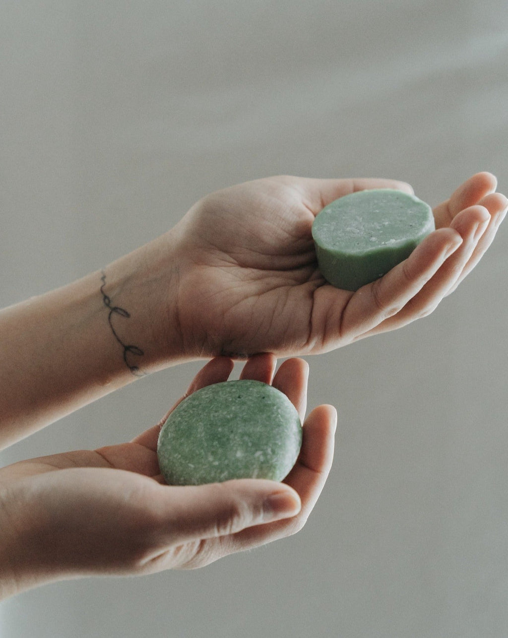 Oh Canada Gifts peppermint and eucalyptus solid conditioner bars held in hands for a zero-waste hair care routine.