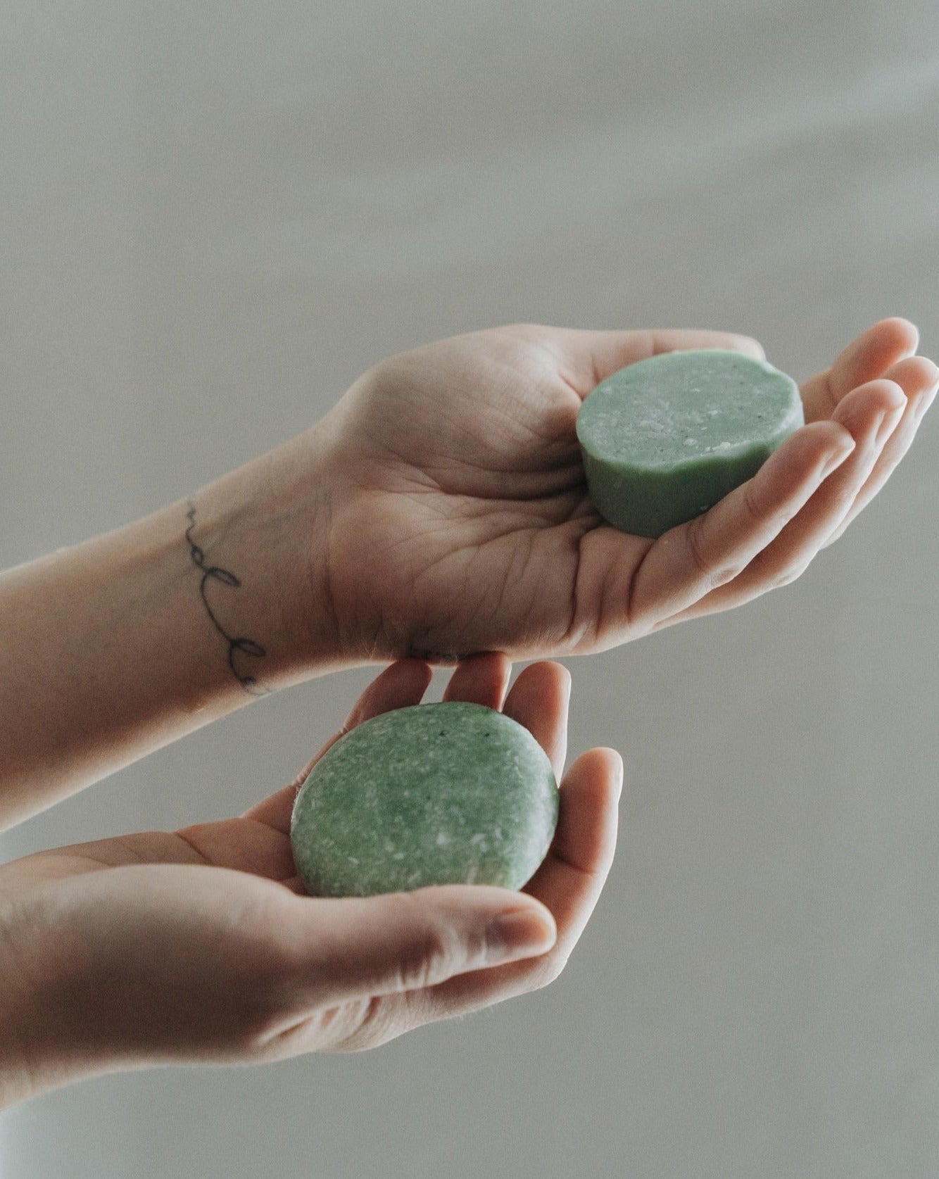 Oh Canada Gifts peppermint and eucalyptus solid conditioner bars held in hands for a zero-waste hair care routine.
