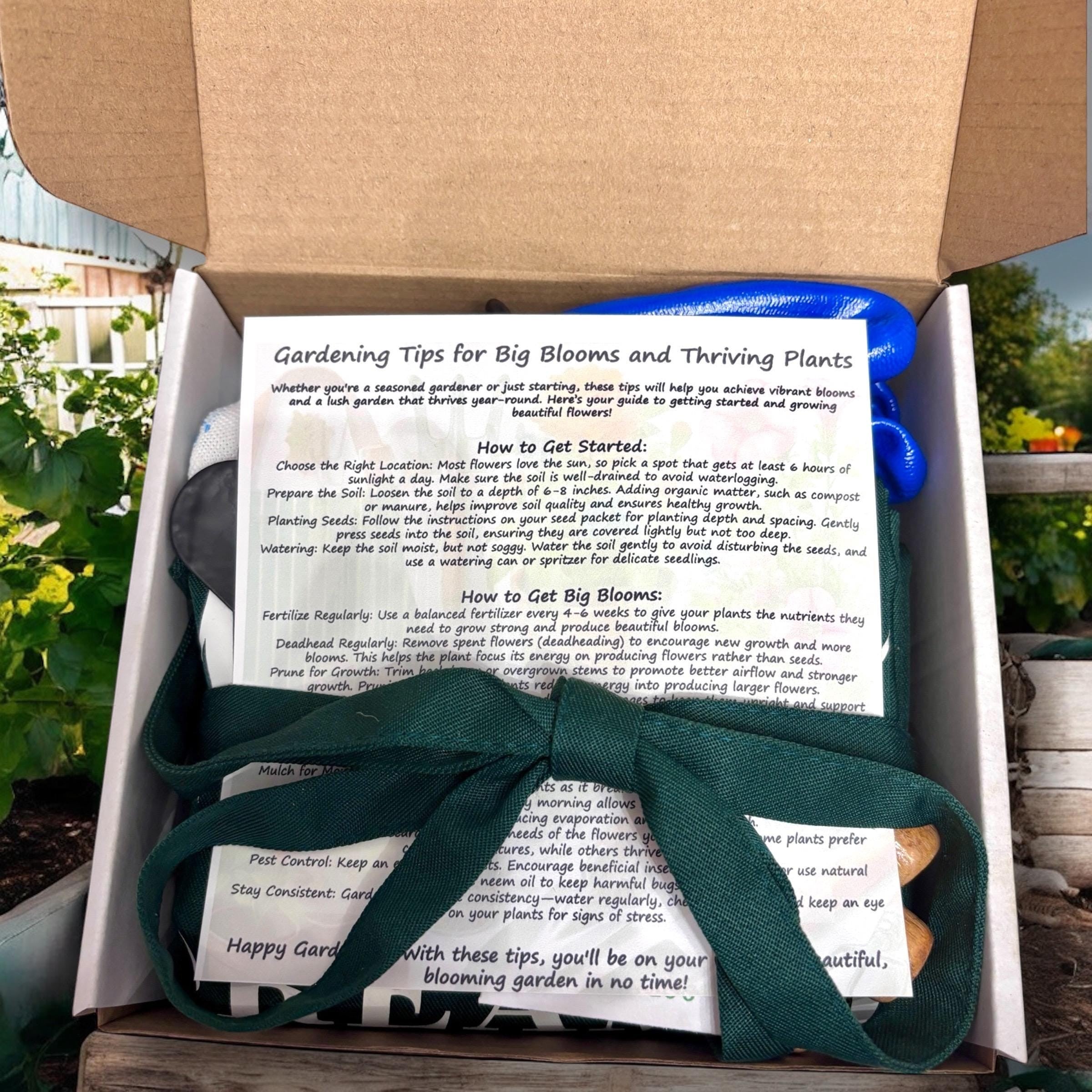 Oh Canada Gifts spring garden starter kit with gardening tips, green apron, and tools inside an open box.