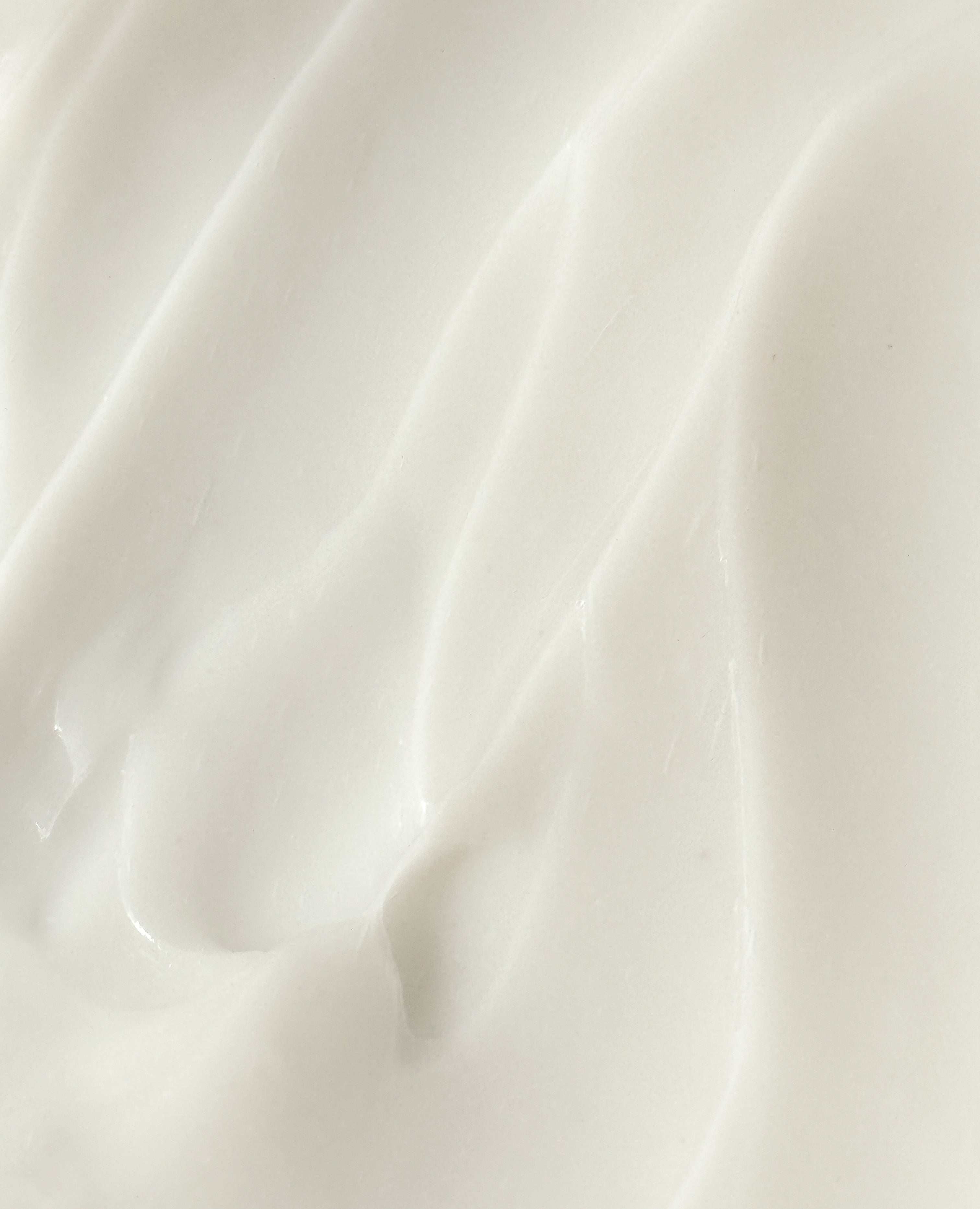 Close-up texture of Oh Canada Gifts stretch mark care cream showing a smooth, rich, white moisturizing formula.