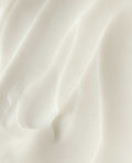Close-up texture of Oh Canada Gifts stretch mark care cream showing a smooth, rich, white moisturizing formula.