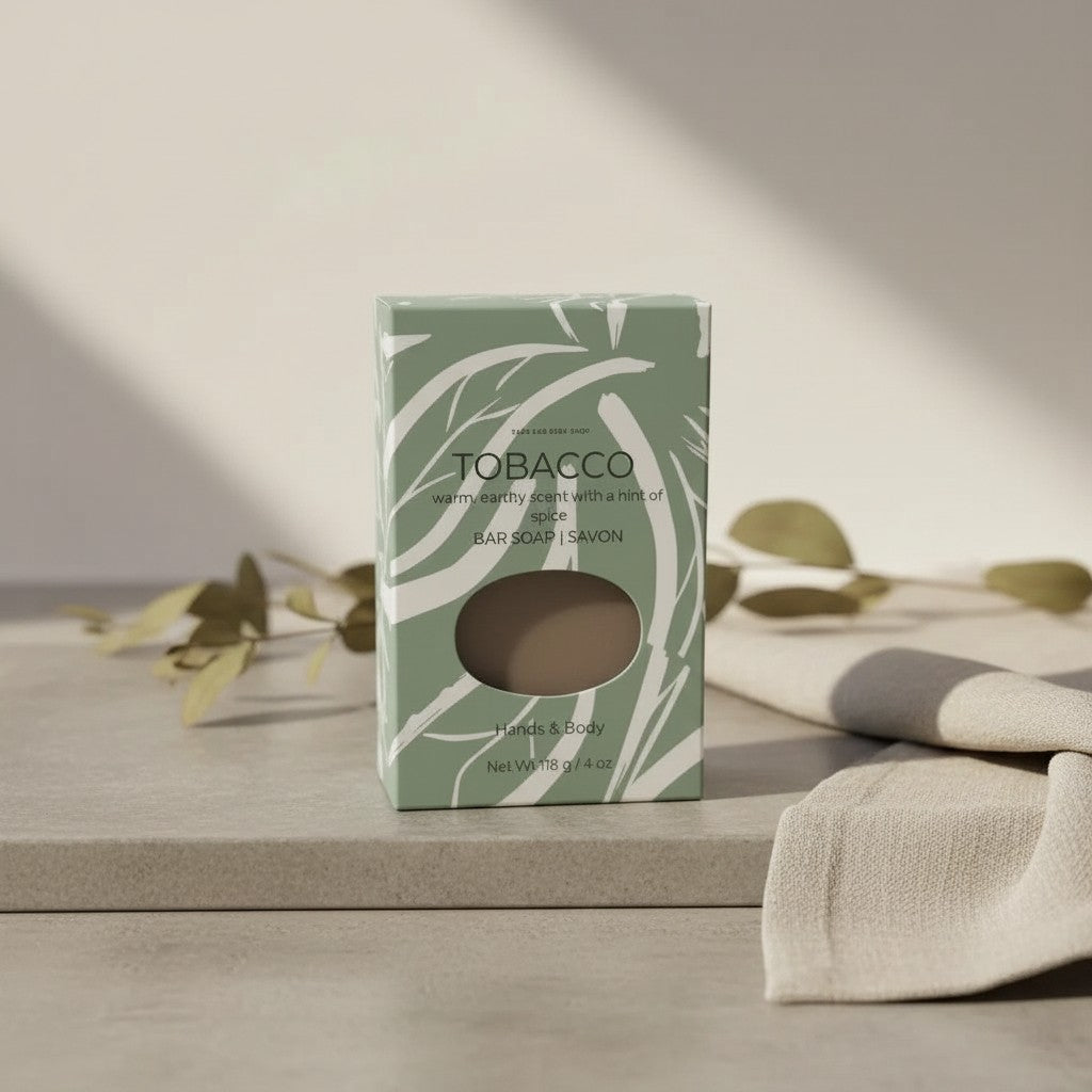 Oh Canada Gifts Tobacco Leaf soap bar in green patterned packaging on a stone surface with a linen cloth.