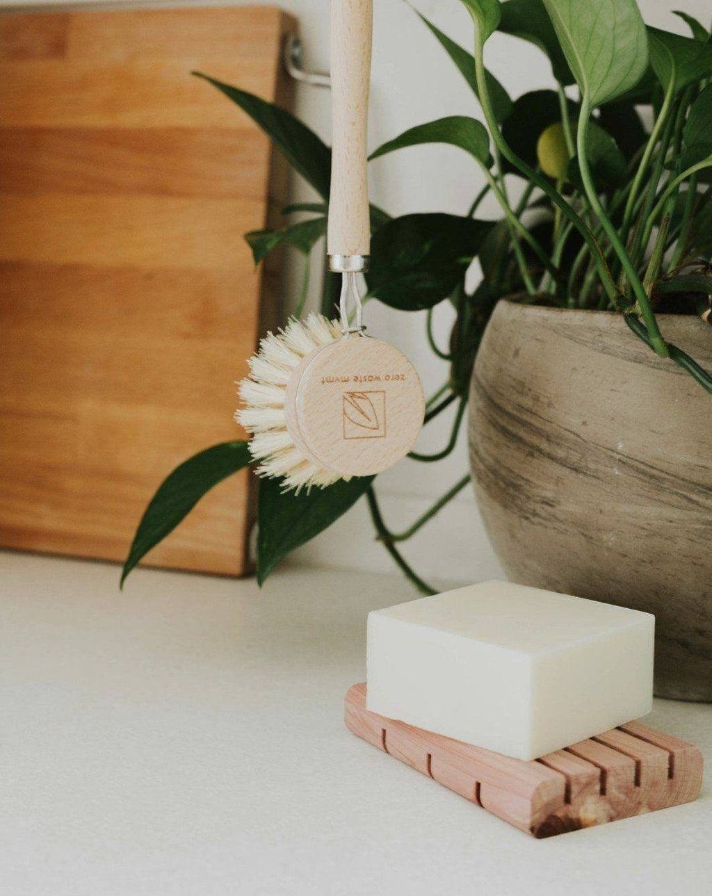Oh Canada Gifts unscented solid dish soap bar on a cedar tray with a wooden dish brush in a bright kitchen setting.